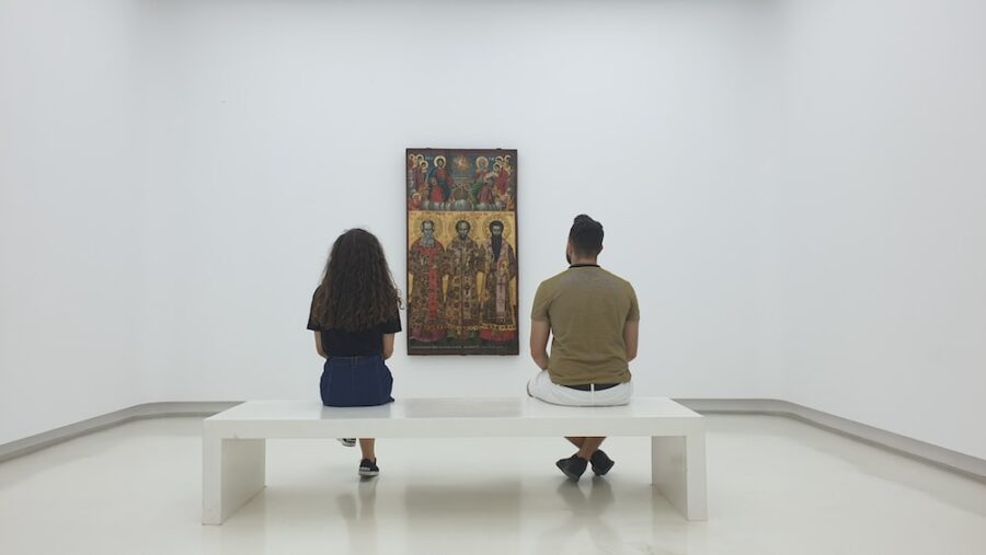 two persons sitting near each other and looking at artwork visiting museum is one of the best first date ideas